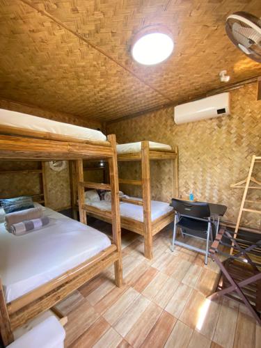 a room with three bunk beds and a desk at Hidden Haven Coron in Coron