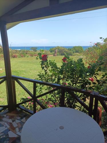 a balcony with a table and a view of a field at Cabañas MANA NUI INN in Hanga Roa