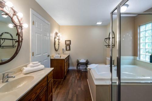 a bathroom with a tub and a sink at Los Lagos at Hot Springs Village a Ramada by Wyndham in Hot Springs Village