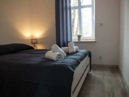 1 dormitorio con 1 cama con toallas en Apartament Plac Piastowski 1, en Jelenia Góra