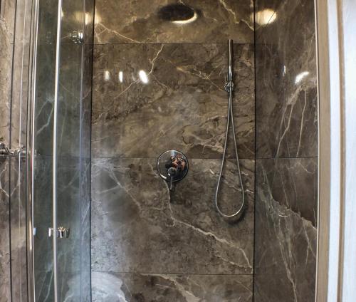 ducha con puerta de cristal y cabezal de ducha en Apartament Plac Piastowski 1, en Jelenia Góra