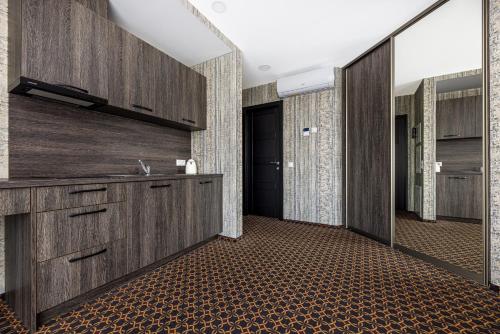 a bathroom with wooden cabinets and a sink and a hallway at Resort Hotel Elija in Šventoji