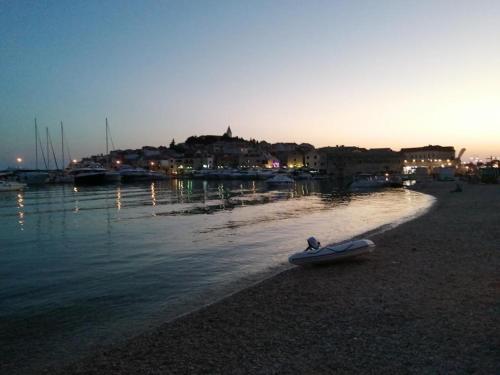 a boat sitting on the shore of a body of water at Apartment in Primosten with sea view, balcony, air conditioning, WiFi 5155-1 in Primošten