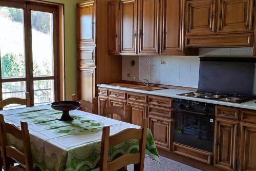 una cocina con armarios de madera y una mesa con mantel. en Il canto del gallo - Country house, en Cassinasco