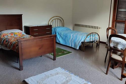 een slaapkamer met een bed, een dressoir en stoelen bij Il canto del gallo - Country house in Cassinasco