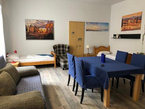ein Wohnzimmer mit einem blauen Tisch und einem Sofa in der Unterkunft Három Tarka Macska Apartmanok in Sárospatak