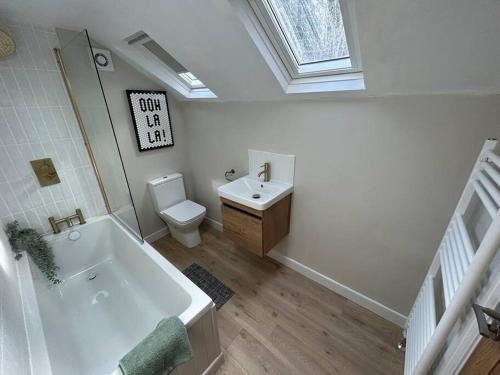 a bathroom with a tub and a toilet and a sink at Caernarfon modern townhouse Snowdonia in Caernarfon