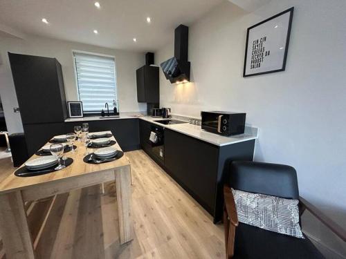 a kitchen with a wooden table and a counter top at Caernarfon modern townhouse Snowdonia in Caernarfon