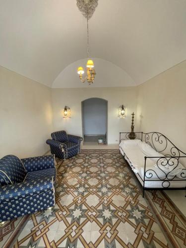 a living room with a bed and a couch at Novecento Country House in Vieste