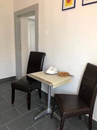 a table and two chairs in a room at Három Tarka Macska Apartmanok in Sárospatak