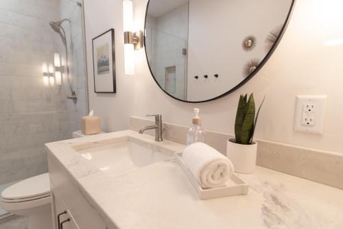 a white bathroom with a sink and a mirror at Colony Suites in Palmer