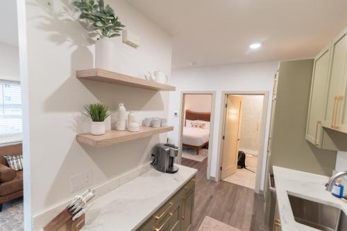 a kitchen with white counters and a sink and a room at Colony Suites in Palmer