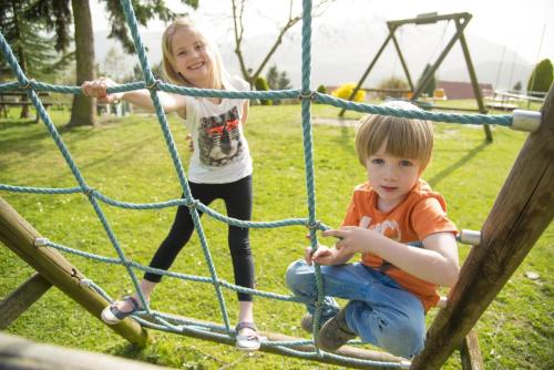a young boy and girl playing on a playground at Michlhof in Stubenberg