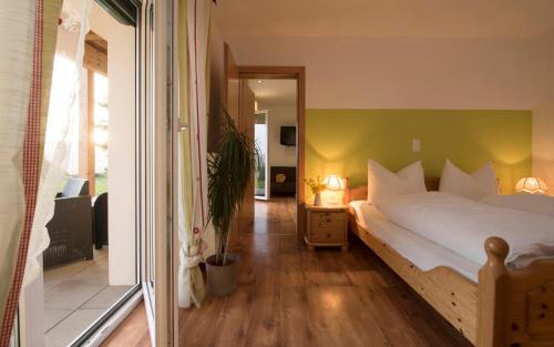 een slaapkamer met een bed met een groene muur bij Michlhof in Zeil