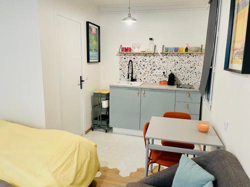 a bedroom with a bed and a table and a kitchen at STUDIO Retro MARAIS- Paris Center in Paris