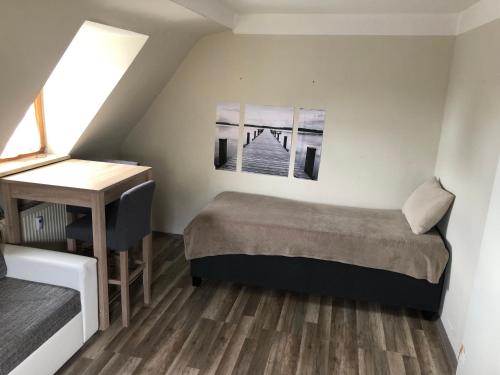 ein kleines Schlafzimmer mit einem Bett und einem Schreibtisch in der Unterkunft Zirndorf Ferienhaus in Zirndorf