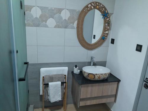 een badkamer met een wastafel en een spiegel bij J&J in Centre de Flacq