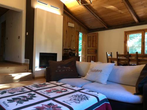 a living room with a couch and a bed at Chalet Leonard House in the wood in Pennabilli