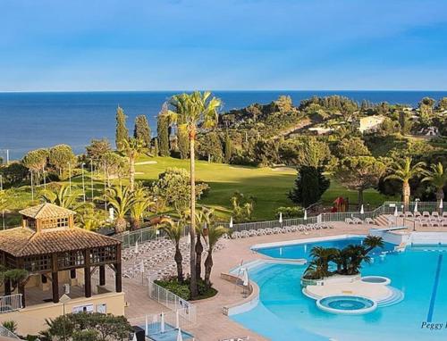 un complexe avec une piscine, un kiosque et l'océan dans l'établissement Superbe duplex T3 climatisé avec Terrasse et Solarium, magnifique vue Mer et Golf, à Saint-Raphaël