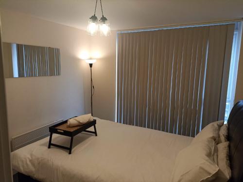 a bedroom with a bed with a table on it at City Center Leicester in Leicester