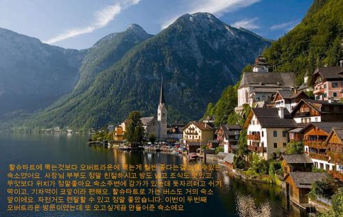 a town on a lake with mountains in the background at B&B Simmer in Obertraun