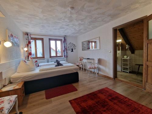 a bedroom with a large bed and a dining room at Zum Alten Schulhaus in Burg