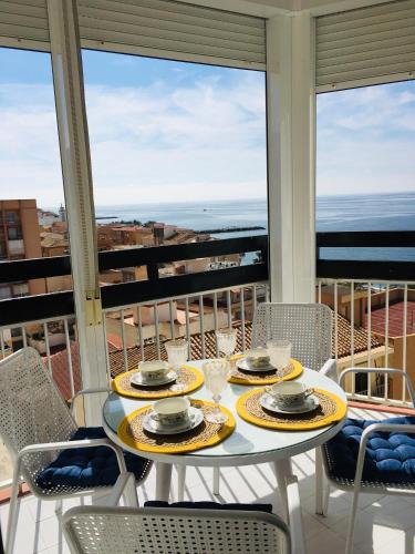 a table on a balcony with a view of the ocean at TODIMER TORRECOSTA in Torrenueva