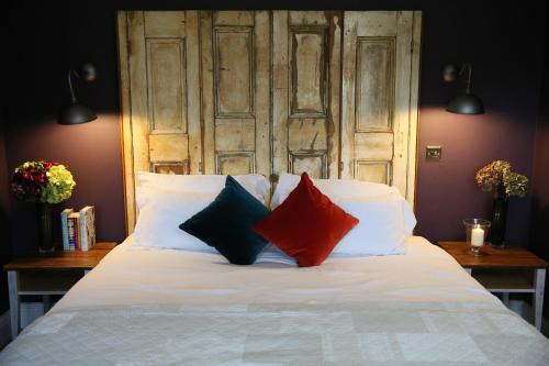 a bed with four pillows and a wooden headboard at The Bunk Inn in Newbury