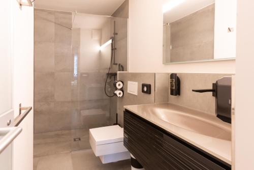 ein Badezimmer mit einem Waschbecken, einem WC und einer Badewanne in der Unterkunft Boutiquehotel am Dom in Salzburg