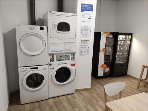 Duas máquinas de lavar roupa e um frigorífico num quarto em Albergue & Rooms Murgadán em Padrón