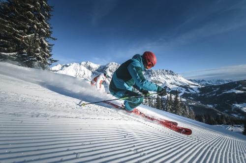 a person is skiing down a snow covered slope at AlpenParks Hotel & Apartment Hochkönig in Mühlbach am Hochkönig