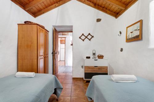 2 camas en una habitación blanca con pasillo en El Lagar, en Icod de los Vinos
