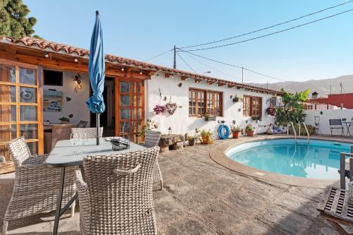 a patio with a table and chairs and a pool at El Lagar in Icod de los Vinos