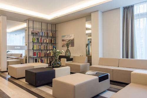 a living room with couches and a book shelf at Grand Baltic Dunes Hotel & SPA in Palanga