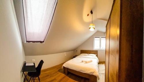 a small bedroom with a bed and a window at XXL Rooms Osijek in Osijek