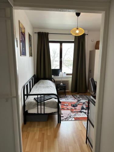 a bedroom with a bed and a large window at Cozy apartment in Vallila - Helsinki in Helsinki