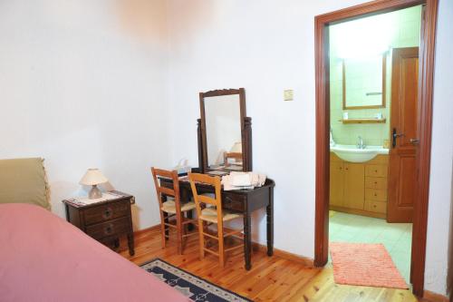 1 dormitorio con escritorio, espejo y lavamanos en CASA IRENE, en Kakopetria