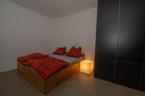 a bedroom with a bed with red pillows on it at Kubus in Memmingen