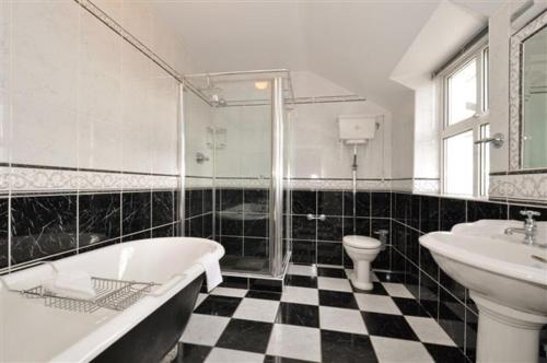 La salle de bains est pourvue d'une baignoire, d'un lavabo et de toilettes. dans l'établissement Claremount House B&B, à Galway