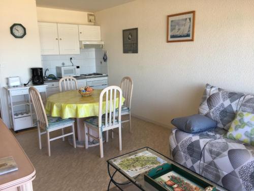 un salon avec une table et une cuisine dans l'établissement Fort-Mahon-Plage : Appartement cosy à deux pas de la mer, animaux admis, parking privatif - FR-1-482-27, à Fort-Mahon-Plage