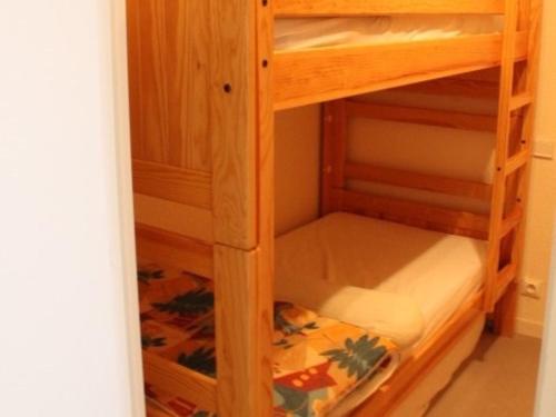 Cette chambre dispose de lits superposés en bois. dans l'établissement Fort-Mahon-Plage : Appartement cosy à deux pas de la mer, animaux admis, parking privatif - FR-1-482-27, à Fort-Mahon-Plage