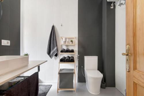 a bathroom with a white toilet and a sink at Casa Turquesa in Tamaraceite