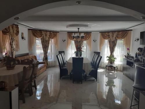 a dining room with a table and chairs and a couch at Magura Raraului in Câmpulung Moldovenesc
