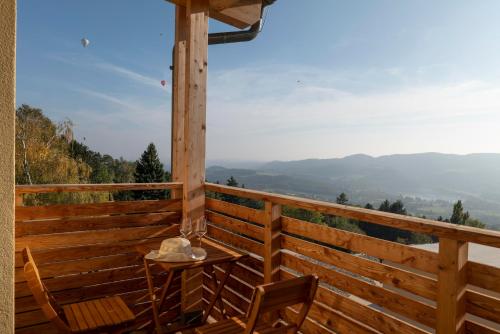 a table and chairs on a wooden balcony with a view at Michlhof in Stubenberg
