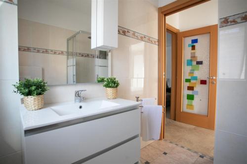 Baño blanco con lavabo y espejo en IseoLakeRental - Appartamento Iris en Solto Collina