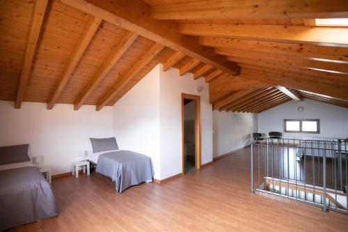 Habitación con 2 camas y techo de madera. en IseoLakeRental - Appartamento Iris en Solto Collina
