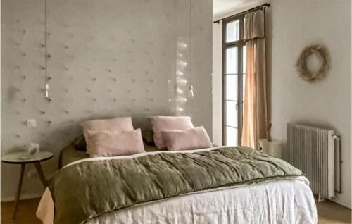 a bedroom with a bed with pink pillows on it at Cozy Home In Valros With Wifi in Valros