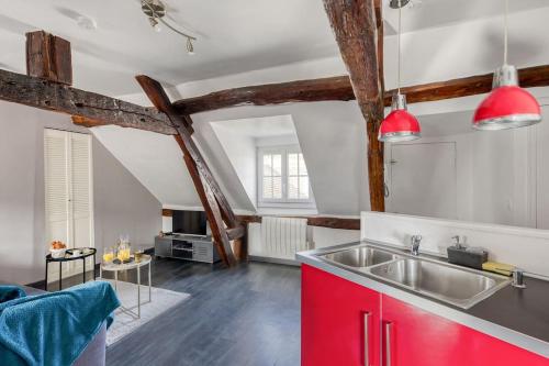 cocina con fregadero y armario rojo en La Nuit du Drouais - T2 en plein cœur de Ville !, en Dreux