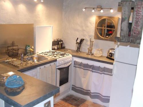 a kitchen with a white stove and a sink at Gîte de charme La Forge in Preuilly-sur-Claise
