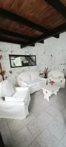Piran Loft في بوينس آيرس: غرفة معيشة مع كنب وطاولات بيضاء